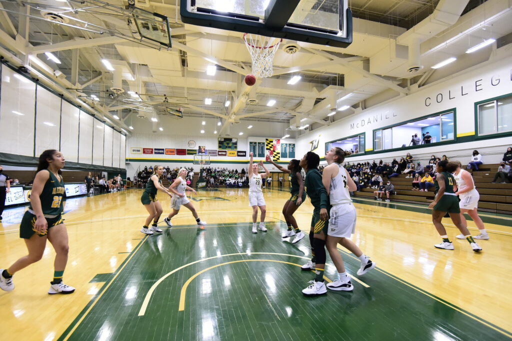 Womens basketball players compete with a rival team.