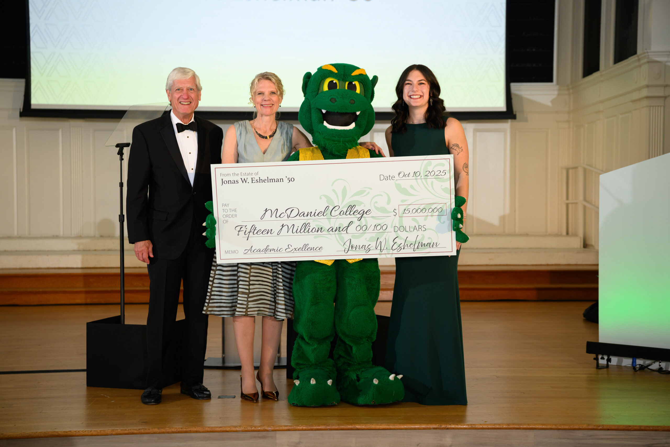 McDaniel Board of Trustees Chair Bruce Preston '75, McDaniel President Julia Jasken, student Nicki James, and the Green Terror pose with an oversized check