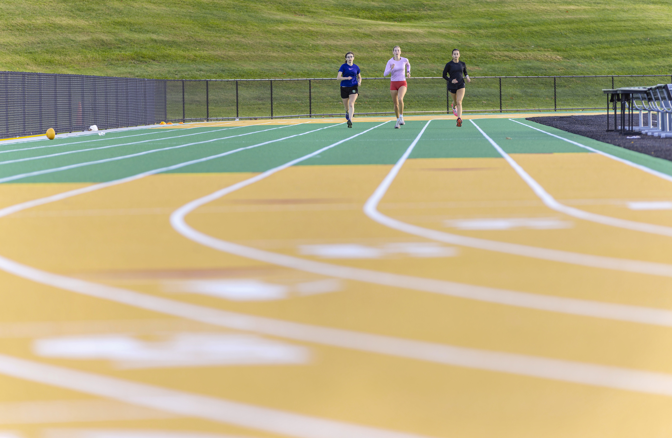 Three students running on the renovated track.